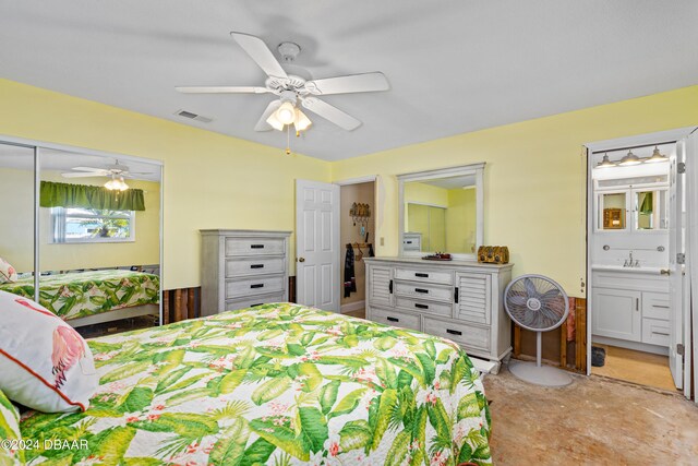 bedroom featuring ceiling fan, a closet, ensuite bathroom, and sink