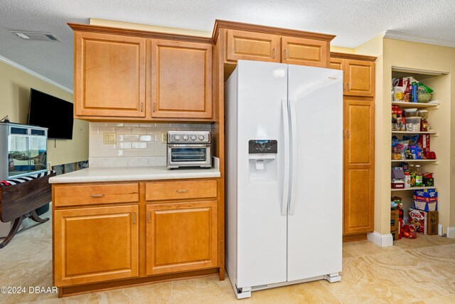 kitchen featuring decorative backsplash, ornamental molding, a textured ceiling, light tile patterned floors, and white fridge with ice dispenser