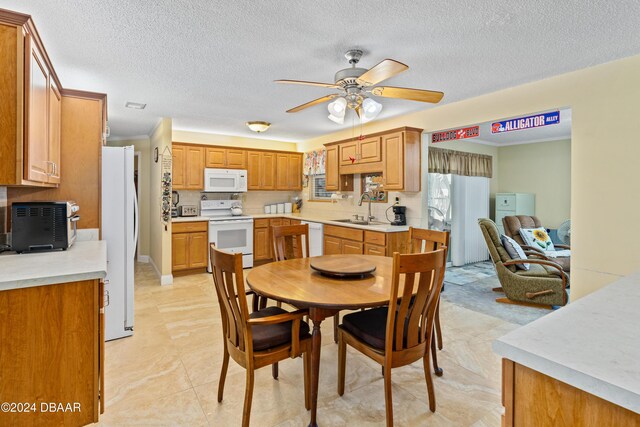 dining space with light tile patterned floors, a textured ceiling, ceiling fan, and sink