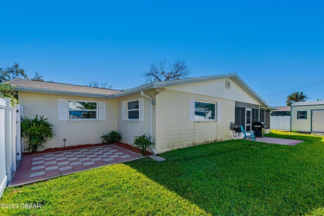 back of property with a yard and a patio