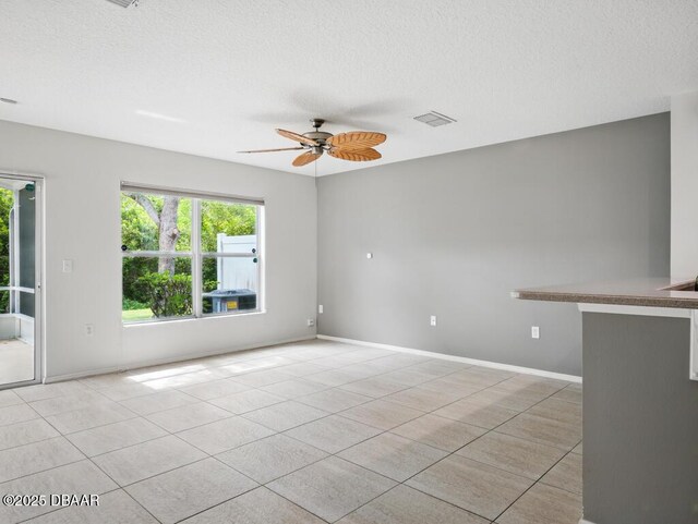 567 Mount Olympus Blvd, New Smyrna Beach, FL 32168 - unfurnished room featuring light tile patterned flooring, a ceiling fan, a textured ceiling, and baseboards
