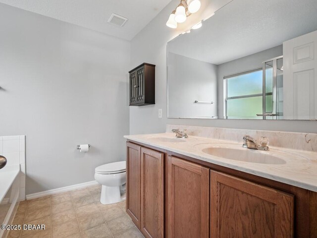 567 Mount Olympus Blvd, New Smyrna Beach, FL 32168 - full bath featuring baseboards, toilet, double vanity, a garden tub, and an enclosed shower