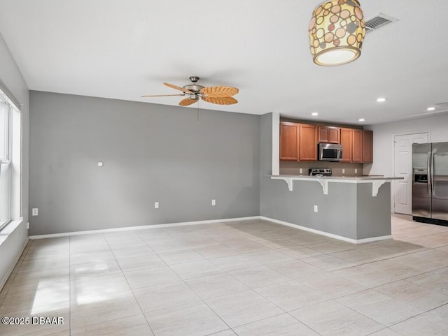 567 Mount Olympus Blvd, New Smyrna Beach, FL 32168 - kitchen with stainless steel appliances, a peninsula, a kitchen breakfast bar, light countertops, and recessed lighting
