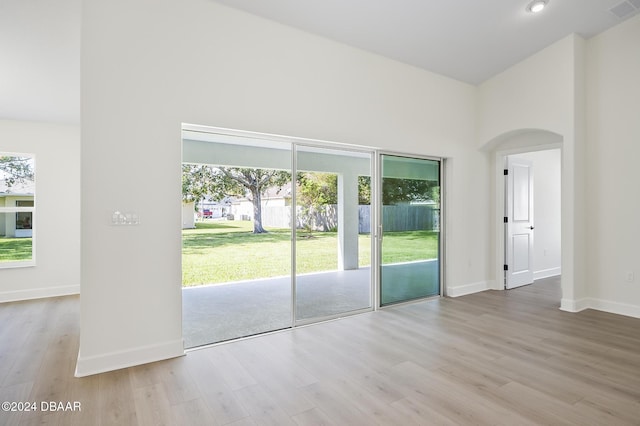 111 Bird Of Paradise Dr, Palm Coast, FL 32137 - empty room with wood finished floors, arched walkways, baseboards, and a high ceiling