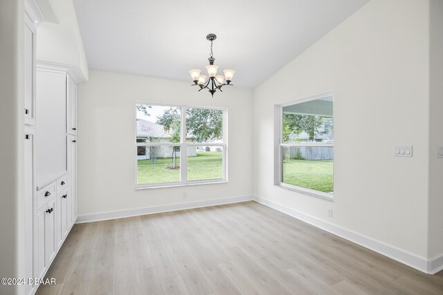 111 Bird Of Paradise Dr, Palm Coast, FL 32137 - unfurnished dining area with lofted ceiling, a chandelier, light wood-style floors, and baseboards