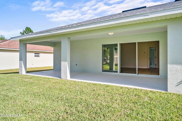 rear view of house featuring a yard and a patio area