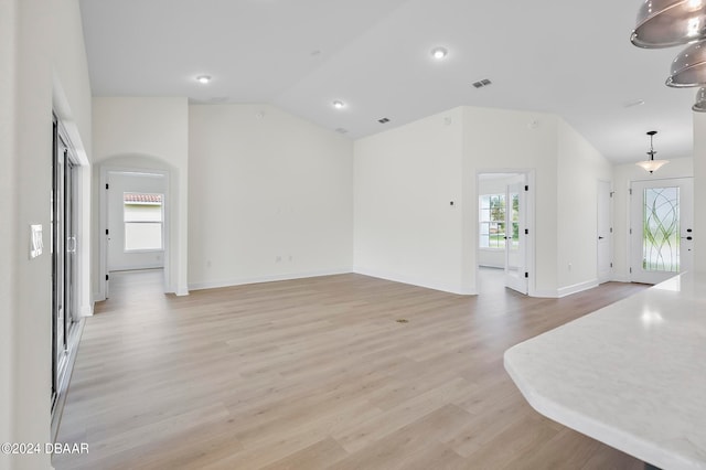 interior space featuring lofted ceiling and light hardwood / wood-style flooring