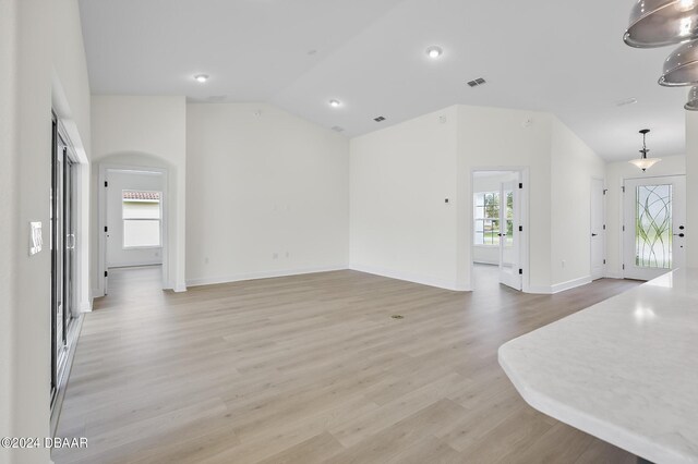 111 Bird Of Paradise Dr, Palm Coast, FL 32137 - unfurnished living room with lofted ceiling, light wood finished floors, and baseboards