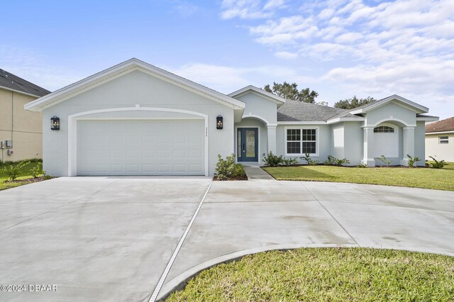 111 Bird Of Paradise Dr, Palm Coast, FL 32137 - ranch-style house with driveway, stucco siding, a front lawn, and a garage
