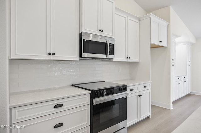111 Bird Of Paradise Dr, Palm Coast, FL 32137 - kitchen with stainless steel microwave, electric range, light wood-style floors, white cabinetry, and light countertops