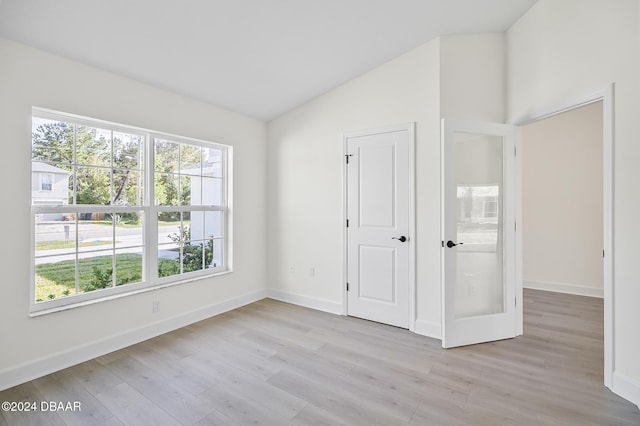 111 Bird Of Paradise Dr, Palm Coast, FL 32137 - unfurnished bedroom with light wood-style flooring, vaulted ceiling, and baseboards