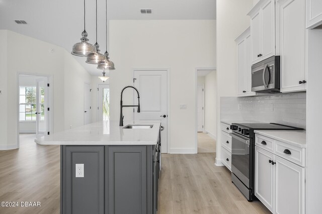111 Bird Of Paradise Dr, Palm Coast, FL 32137 - kitchen featuring electric stove, stainless steel microwave, a sink, light wood-style floors, and baseboards