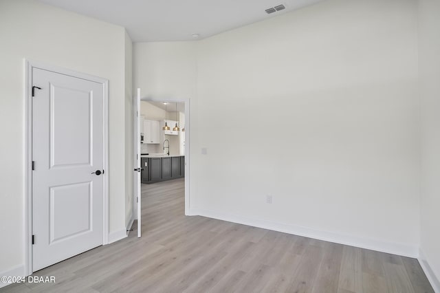 111 Bird Of Paradise Dr, Palm Coast, FL 32137 - spare room featuring light wood-style floors, baseboards, and a sink
