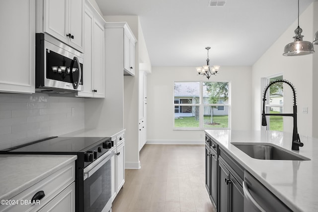 111 Bird Of Paradise Dr, Palm Coast, FL 32137 - kitchen with stainless steel appliances, a sink, light countertops, white cabinets, and vaulted ceiling