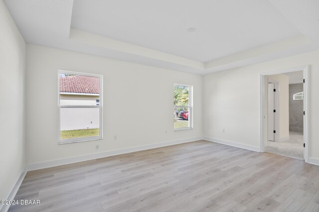 111 Bird Of Paradise Dr, Palm Coast, FL 32137 - spare room with a raised ceiling, light wood-type flooring, and baseboards