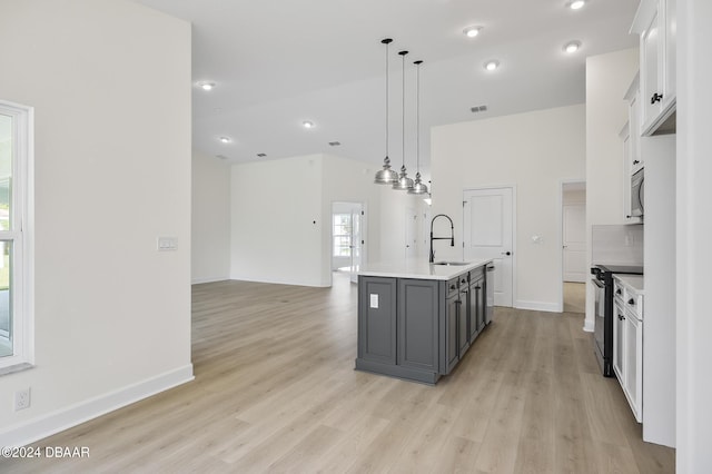 111 Bird Of Paradise Dr, Palm Coast, FL 32137 - kitchen with appliances with stainless steel finishes, white cabinets, light wood-type flooring, light countertops, and hanging light fixtures