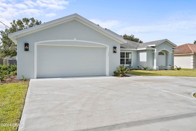 ranch-style house featuring a garage and a front lawn