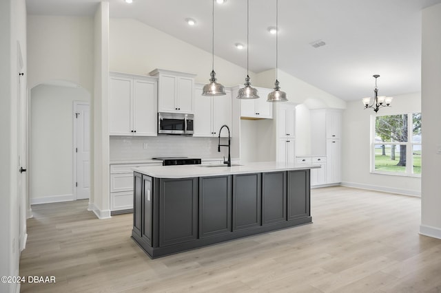 111 Bird Of Paradise Dr, Palm Coast, FL 32137 - kitchen with a sink, stainless steel microwave, white cabinets, backsplash, and high vaulted ceiling