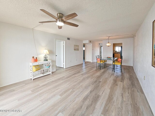 3606 S Peninsula Dr # 404, Port Orange, FL 32127 - living room with wood finished floors, a textured ceiling, ceiling fan, and a chandelier