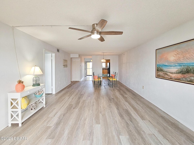 interior space featuring ceiling fan, light hardwood / wood-style floors, and a textured ceiling