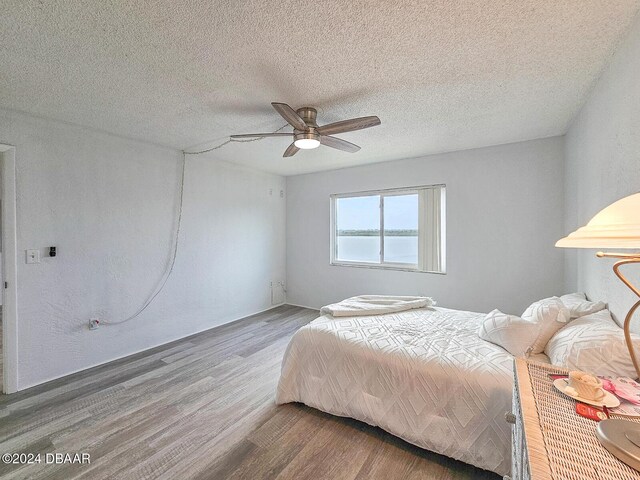 3606 S Peninsula Dr # 404, Port Orange, FL 32127 - bedroom with wood finished floors, a textured ceiling, and ceiling fan