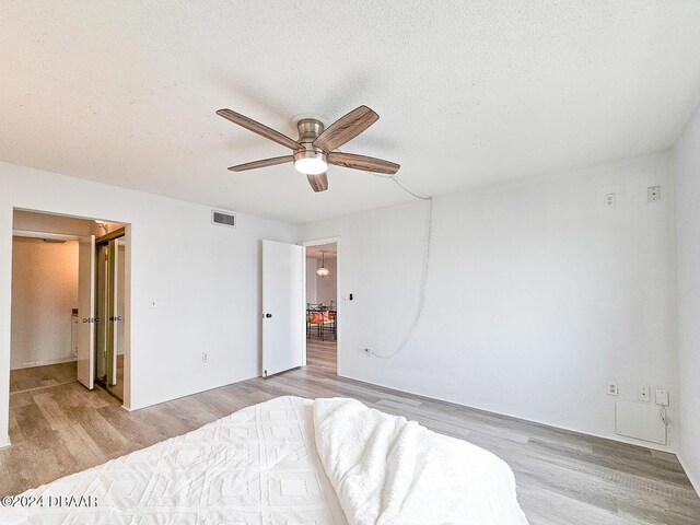 3606 S Peninsula Dr # 404, Port Orange, FL 32127 - bedroom featuring light wood finished floors, ceiling fan, and a textured ceiling