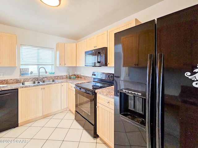 kitchen with light tile patterned flooring, light brown cabinetry, sink, and black appliances