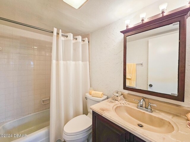 full bathroom featuring vanity, toilet, a textured ceiling, and shower / tub combo with curtain