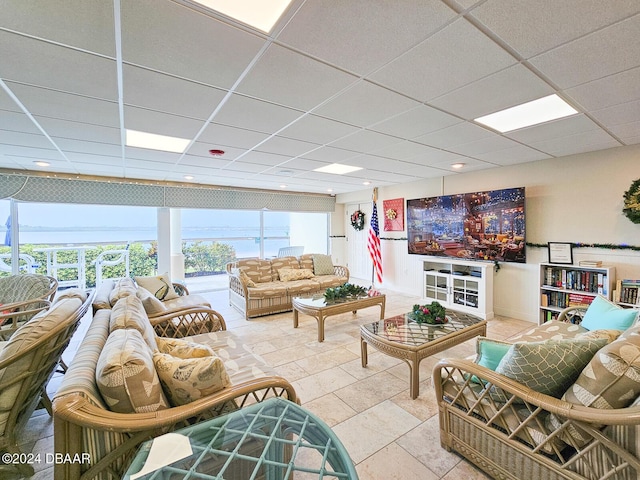 living room featuring tile patterned floors and a drop ceiling