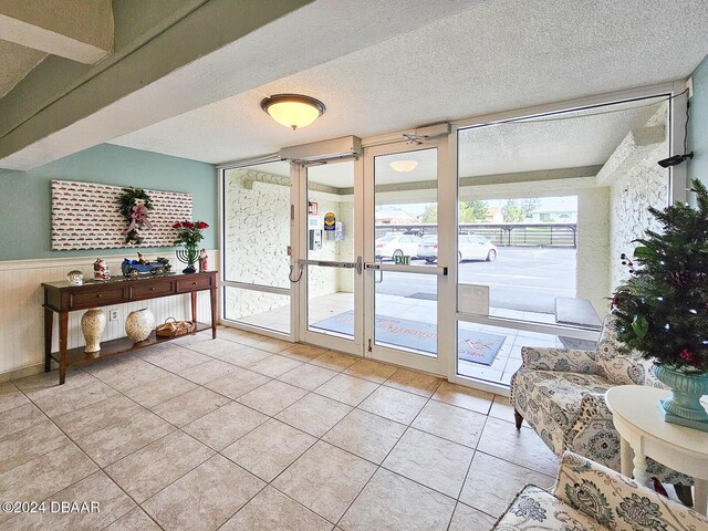 3606 S Peninsula Dr # 404, Port Orange, FL 32127 - doorway to outside featuring tile patterned floors, a wainscoted wall, and a textured ceiling