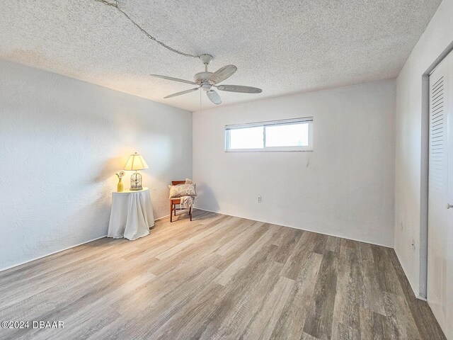 3606 S Peninsula Dr # 404, Port Orange, FL 32127 - bedroom featuring wood finished floors, a textured ceiling, and a ceiling fan
