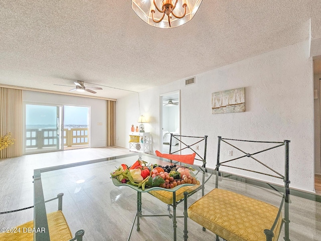 3606 S Peninsula Dr # 404, Port Orange, FL 32127 - interior space featuring a textured ceiling, wood finished floors, a textured wall, and a chandelier