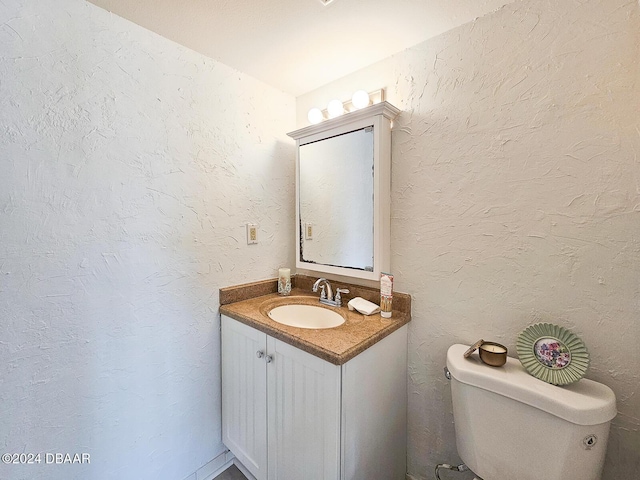 bathroom featuring vanity, toilet, and lofted ceiling