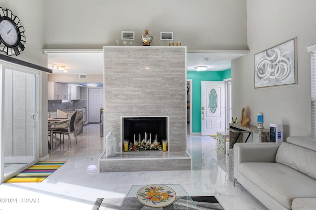 living room with a fireplace and a high ceiling