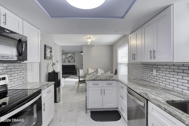 kitchen featuring appliances with stainless steel finishes, light stone countertops, and white cabinets