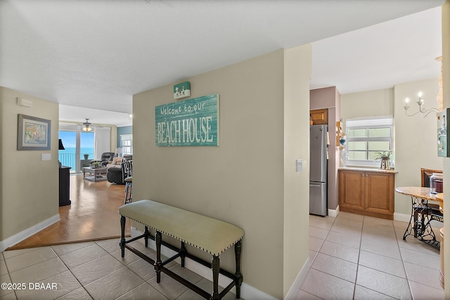 3145 S Atlantic Ave Unit 504, Daytona Beach Shores, FL 32118 - hall with healthy amount of natural light, a chandelier, and light tile patterned floors