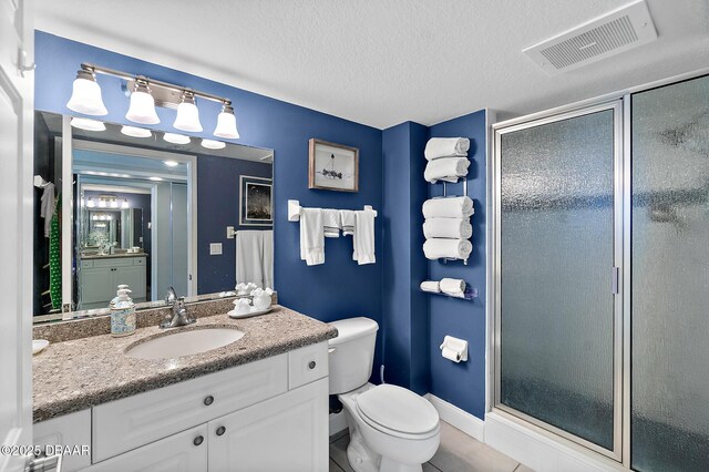 3145 S Atlantic Ave Unit 504, Daytona Beach Shores, FL 32118 - bathroom with vanity, a shower stall, tile patterned floors, and a textured ceiling
