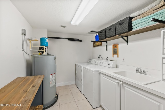 3145 S Atlantic Ave Unit 504, Daytona Beach Shores, FL 32118 - washroom with water heater, cabinet space, separate washer and dryer, and light tile patterned floors