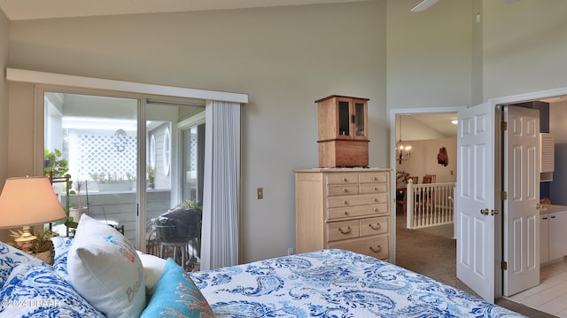 bedroom featuring a towering ceiling, light carpet, and access to outside