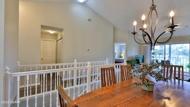 dining space with ceiling fan with notable chandelier and high vaulted ceiling