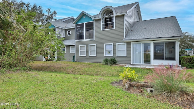 back of house with a yard and a sunroom