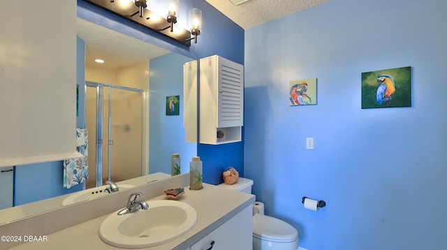 bathroom featuring a shower with door, vanity, a textured ceiling, and toilet