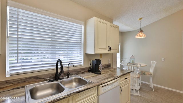 kitchen featuring dishwasher, sink, pendant lighting, and a textured ceiling