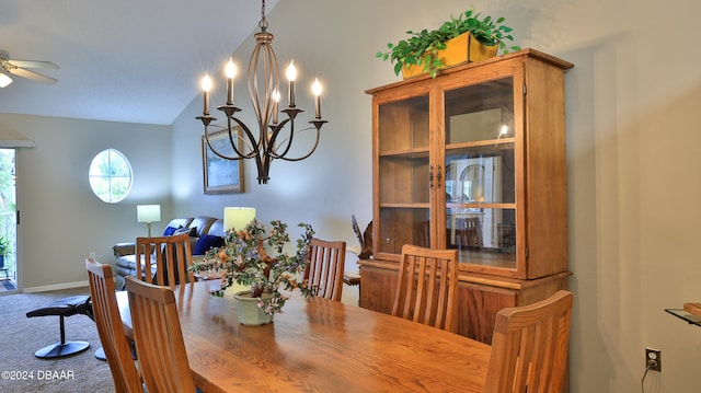 carpeted dining area with ceiling fan with notable chandelier and vaulted ceiling