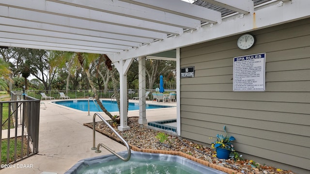 view of swimming pool featuring a community hot tub, a pergola, and a patio