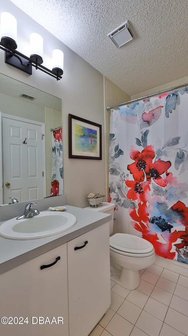 bathroom featuring toilet, a shower with curtain, a textured ceiling, vanity, and tile patterned flooring