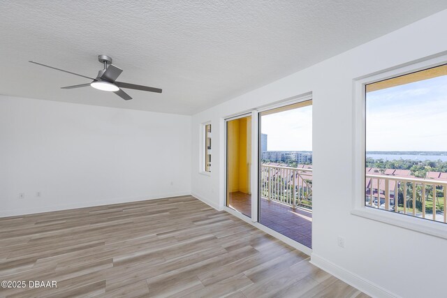 unfurnished room featuring ceiling fan, light hardwood / wood-style flooring, and a textured ceiling