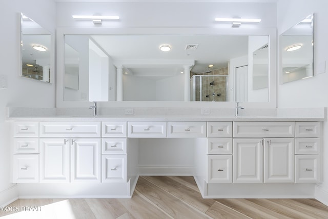 bathroom with vanity, a shower with shower door, and hardwood / wood-style floors