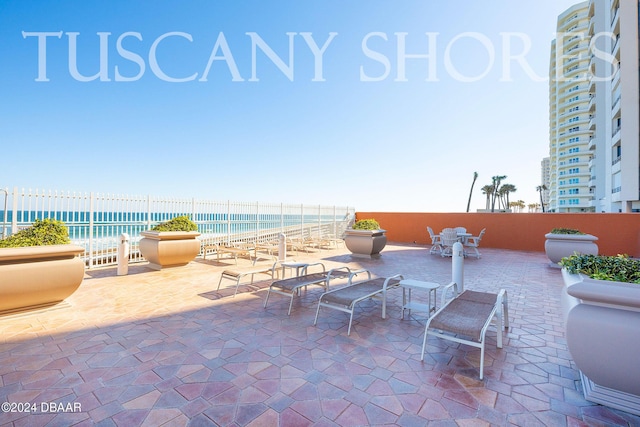 view of patio / terrace with a view of the beach and a water view