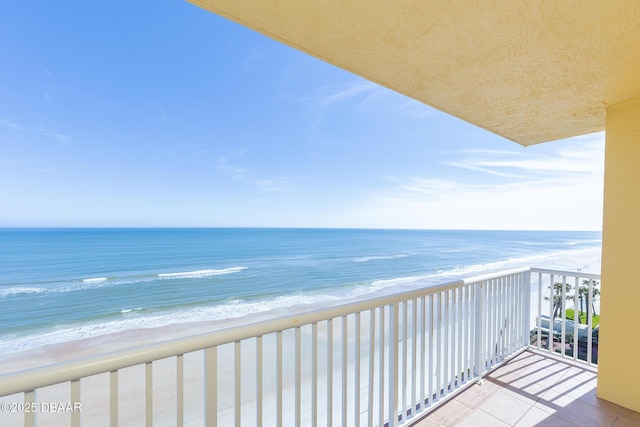 balcony featuring a water view and a beach view